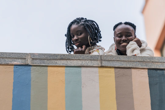 Portrait of smiling friends leaning on wall