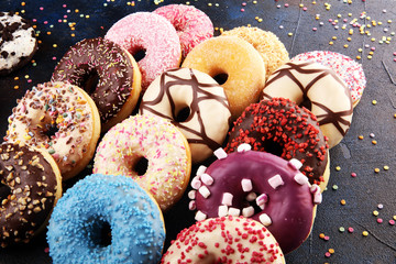 assorted donuts with chocolate frosted, pink glazed and sprinkles donuts