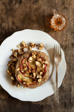 Plate of gluten free buckwheat pancakes with banana, apple and nuts