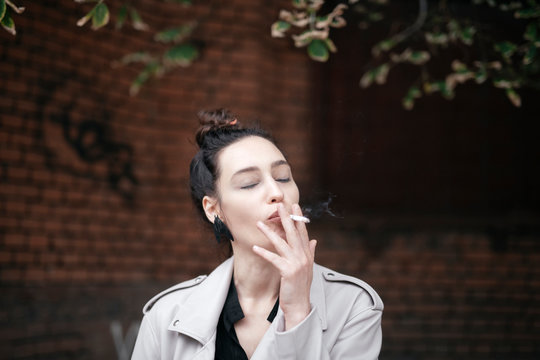 Portrait of woman smoking with eyes closed