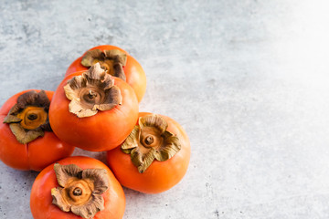 Ripe Fuyu Persimmon Isolated on Light Background, Top View with Copy Space