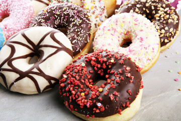 assorted donuts with chocolate frosted, pink glazed and sprinkles donuts