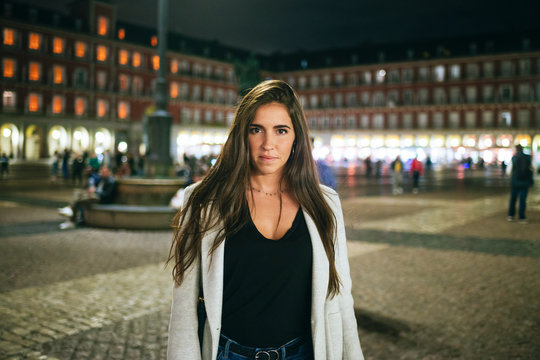 Portrait of a woman standing on Plaza Mayor at night, Madrid, Spain