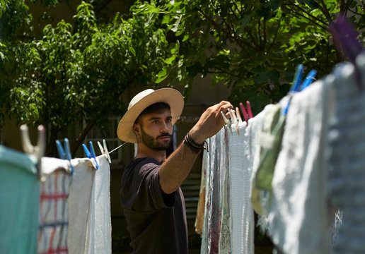 Man hanging up laundry outdoors