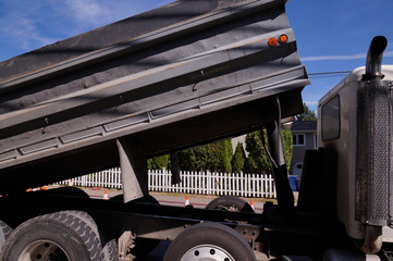 Truck with dump trailer. A large vehicle in city traffic.