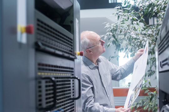 Manager working in printing house, checking paper