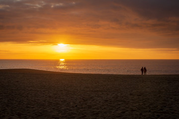 Fototapeta premium Couple seeing the sunset at the beach
