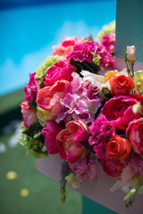 Flowers as a decoration at a wedding. Pink and yellow roses and peonies secured in a flower arrangement at the ceremony.