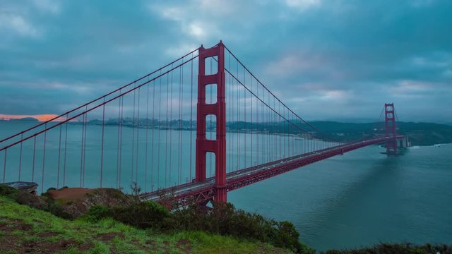 Time lapse of sunrise on a foggy day over the San Francisco golden gate bridge as commuters travel to work. 