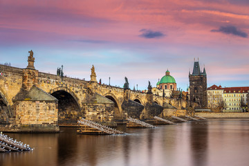 Fototapeta na wymiar Prague, Czech Republic - The world famous Charles Bridge (Karluv most) with a beautiful purple sky and sunset on a winter afternoon