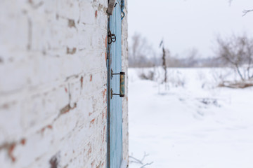 Shed with a blue wooden door. Winter