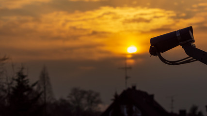 Silhouette von LNB Sat-Empfänger imit terrestischer Antanne im Hintergrund im Sonnenuntergang
