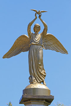 Winged Lady With Dove Golden Statue in Greece