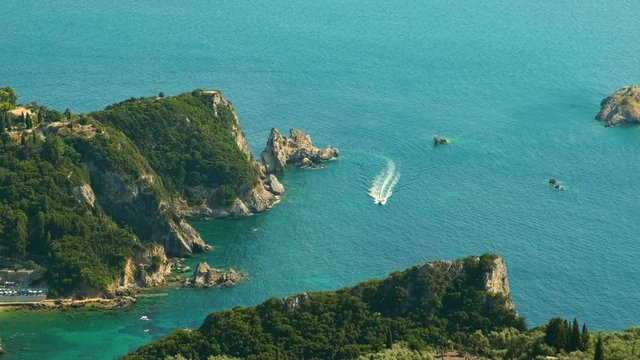View from above on Paleokastritsa bay in a sunny day, Corfu island, Greece. Motor Boat Moving. ProRes 422HQ 10 Bit mov.