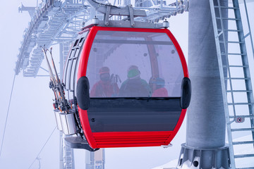Red Cable car in Zillertal Arena ski resort in Tyrol in Mayrhofen in Austria in winter Alps. Chair lifts in Alpine mountains with white snow and blue sky. Downhill fun at Austrian snowy slopes.