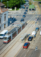 Typical red tram and car transport on road on Museumstrasse of MuseumsQuartier in Innere Stadt of Old city center in Vienna in Austria. Street with traffic in Wien in Europe. Street view.