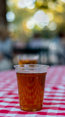 Two glasses of of beer on red chess pattern tablecloth- drinking outside concept