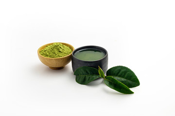 Hot green tea latte in black wooden bowl on white background. Place with deep Green tea leaves out side.