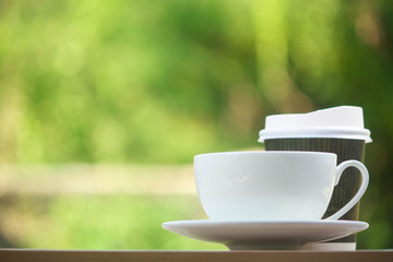 Paper cup take away coffee on a wooden bench in the park