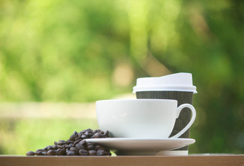 Paper cup take away coffee on a wooden bench in the park