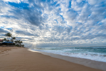 Rays of sunlight shining through a vast sunset sky over Sunset Beach on the north shore of Oahu, Hawaii, USA