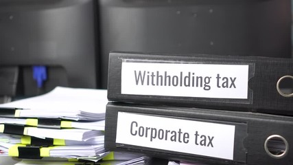 taxes binders concept: Document of Withholding tax and corporate tax for accountant. withholding tax sometimes applies to royalties, rent or even sale of real estate, duty must be paid to government