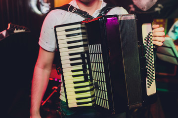Image of musician playing on accordion closeup.
