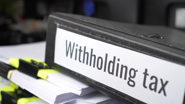 Pile of Taxation document files concept, Withholding tax, retention tax is income tax to paid to government by payer rather than by  recipient, applies to employment income, recipient's tax liability