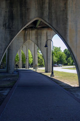 sidewalk beneath old concrete bridge