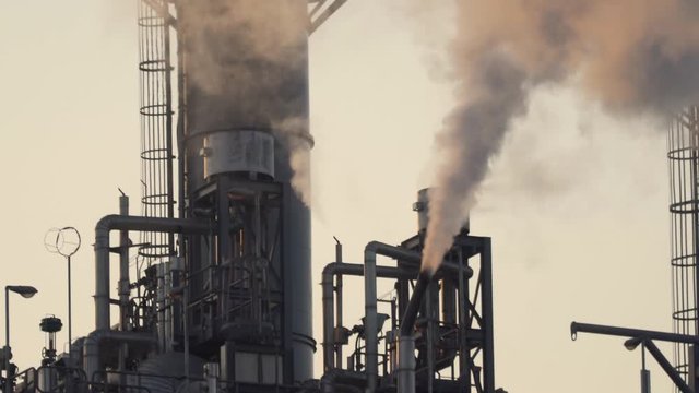 Power plant Billowing steam from smoke stack filling sky. Smoking chimneys from factory. Chimneys of power plant or oil refinery at Sunrise polluting environment. Air Pollution b roll. Slow motion