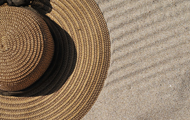 Fototapeta na wymiar Hat on sand texture. Summer time concept.