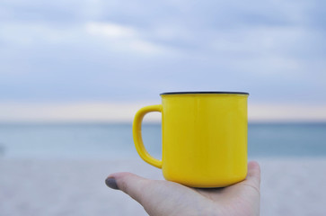  yellow cup on sand.