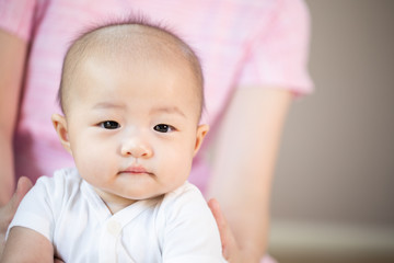 Asian baby happy in the room.Asian baby girl lying down on bed .