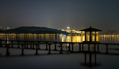 Obraz premium Night view of Chinese Pavillion and Chinese bridge with light decoration at East Lake Wuhan, Hubei, China