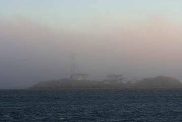 Obraz premium Foggy coastal lighthouse