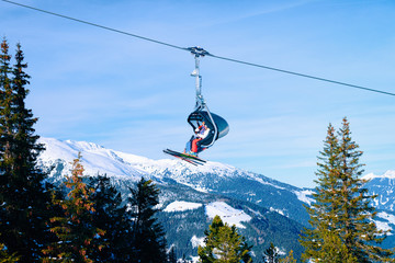 People skiers on Chair lift on Penken park ski resort in Tyrol in Mayrhofen in Zillertal valley,...