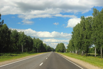 Fototapeta premium Summer empty road landscape, endless highway on Sunny day on trees and blue sky with clouds background