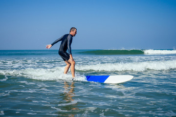 surf instructor showing how riding on big waves in Goa India