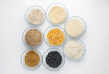 Legumes in glass containers on a table like corn, lentil, rice, oatmeal, beans and quinoa