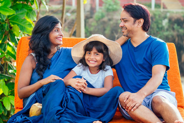 using eco metal recyclable tube.happy asian parents and cute girl enjoying summer vacation in Goa beach , drinking coconut water