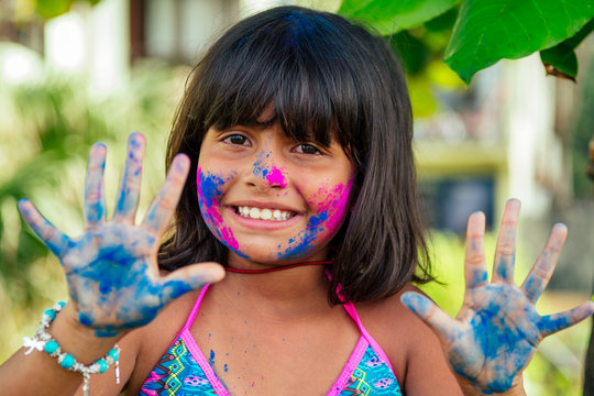 little indian girl painted her face with pink and blue colors