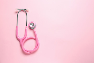 Modern stethoscope on color background