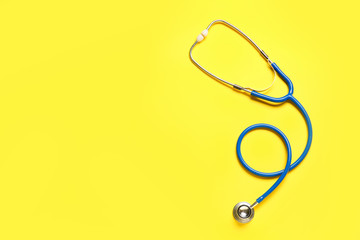 Modern stethoscope on color background