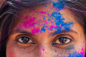 Holi Festival Of Colours. cropped portrait of happy indian girl in holi color. eyes close up