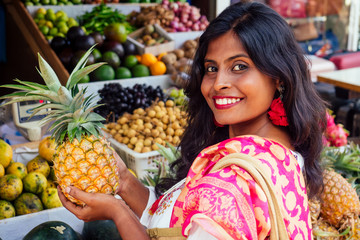 travel girl seller in street market and a buyer in a fruit shop in india delhi.smiling business woman indonesian in kerala goa sell fruit and vegetable farm