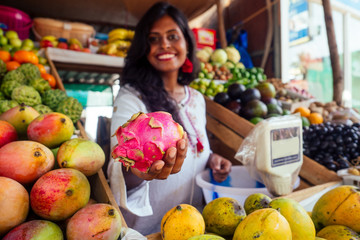 smiling indonesian business woman in kerala goa sell fruit and vegetable farm