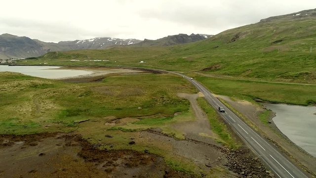 A small road passes near high mountains. Filmed in Iceland during the summer.