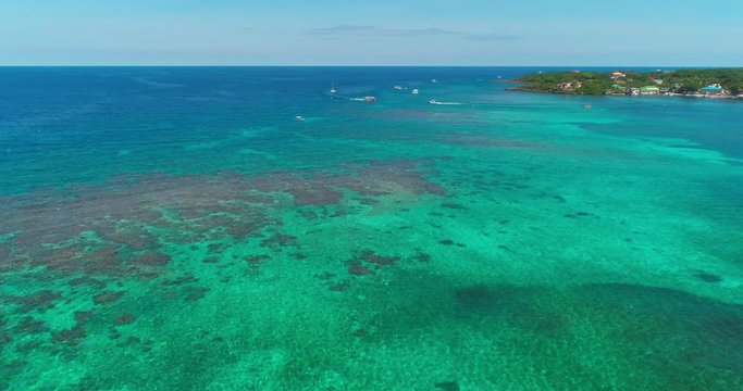 Drone aerial over coral reef to dive boats off coast of island, Roatan