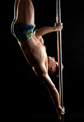 Pole dance. Photo of strong guy posing at camera