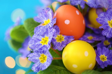 Obraz na płótnie Canvas Easter concept. Easter eggs in the colors of primrose blue on a bright blue background with golden bokeh.Holiday Easter spring bright background.Spring Religious holiday
